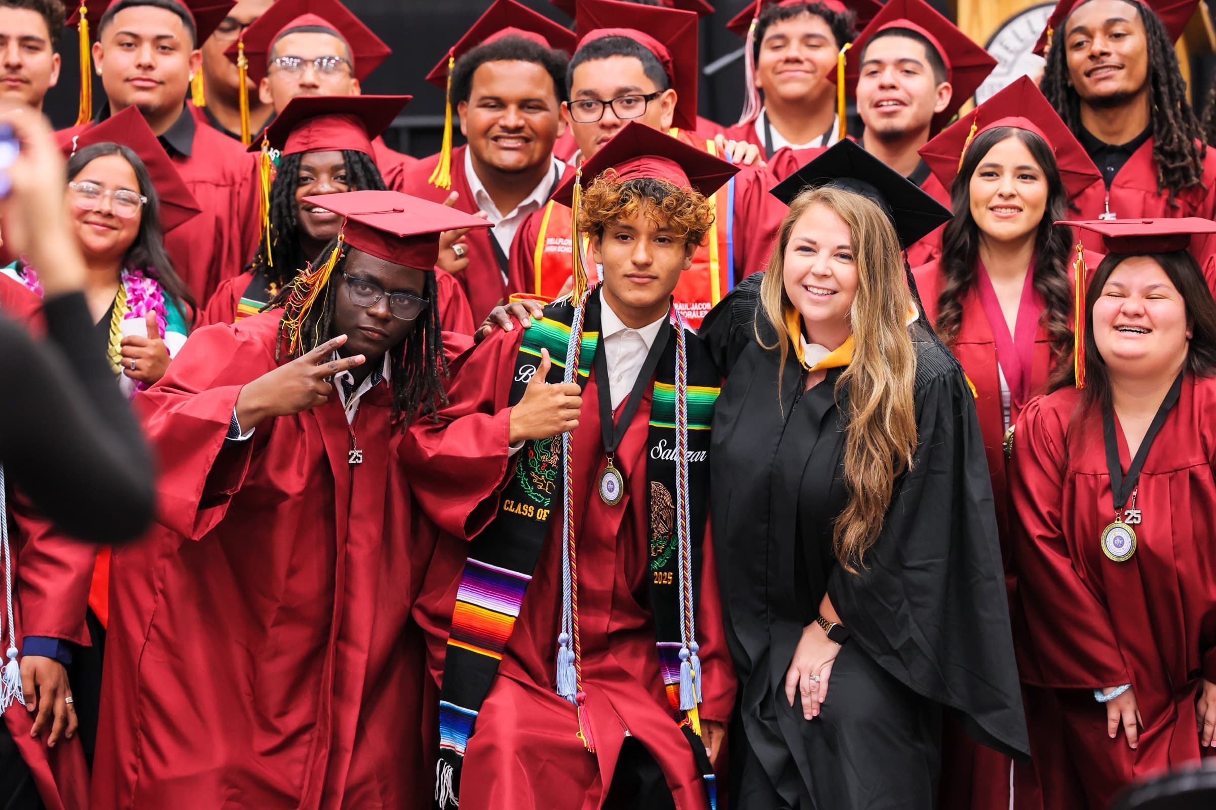 Bellflower High School graduates and a teacher pose together after commencement